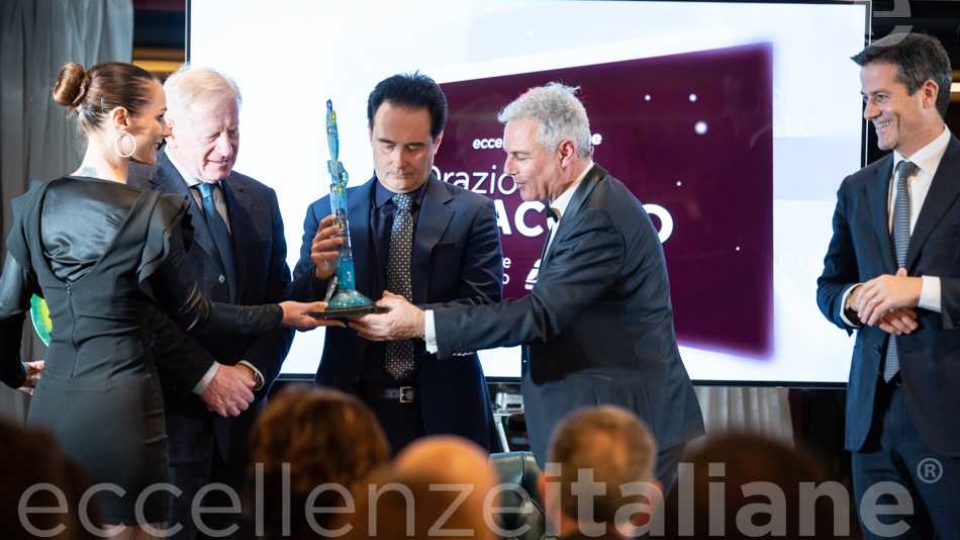 Riccardo Longo consegna il premio Eccellenze Italiane 2019 a Orazio Iacono alla presenza di Sebastiano D'Angelo